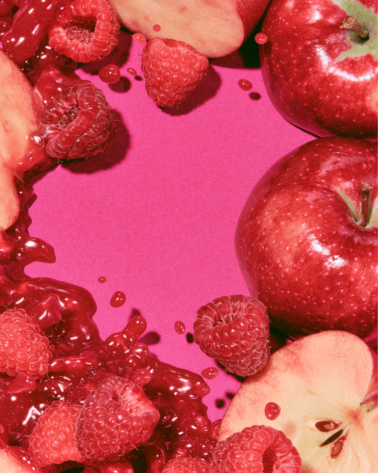 Pommes et framboises fraîches sur fond magenta
